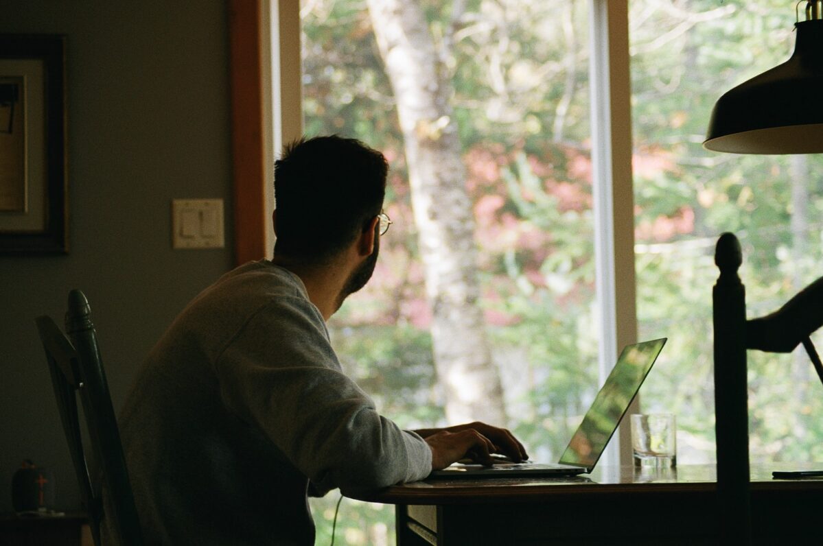 man in gray hoodie using laptop computer
