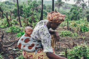 women carrying baby in her back close-up photography